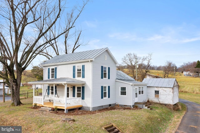 view of front facade with a standing seam roof, metal roof, crawl space, a front lawn, and covered porch