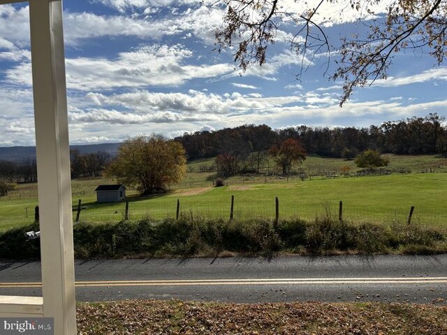 view of yard featuring fence and a rural view