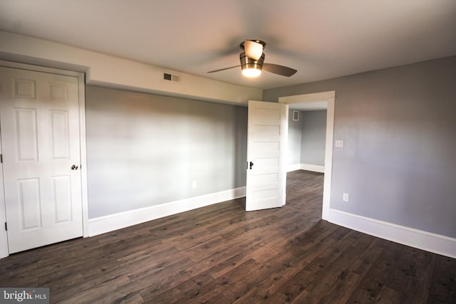 unfurnished bedroom with dark wood finished floors, baseboards, visible vents, and a ceiling fan