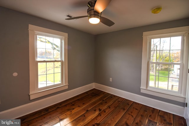 spare room featuring baseboards, dark wood-style floors, and ceiling fan