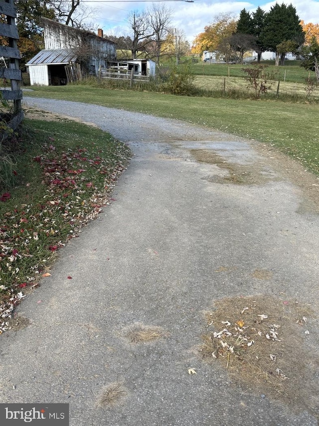 view of street featuring driveway and a pole building