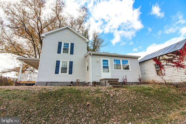rear view of property with a lawn