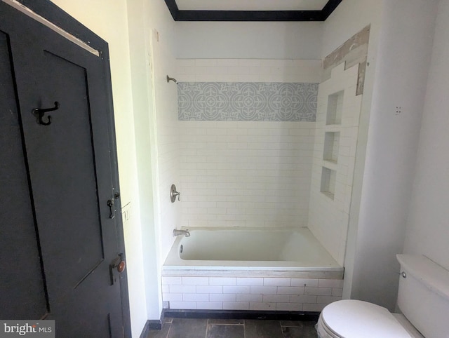 bathroom featuring tile patterned flooring, ornamental molding, toilet, and tiled shower / bath