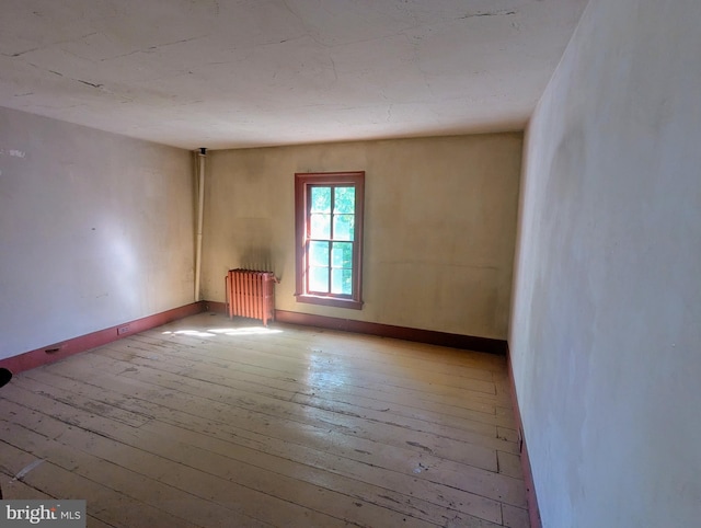 spare room with light wood-type flooring and radiator heating unit