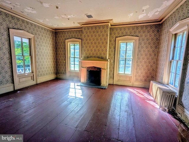 unfurnished living room featuring a brick fireplace, hardwood / wood-style floors, and crown molding