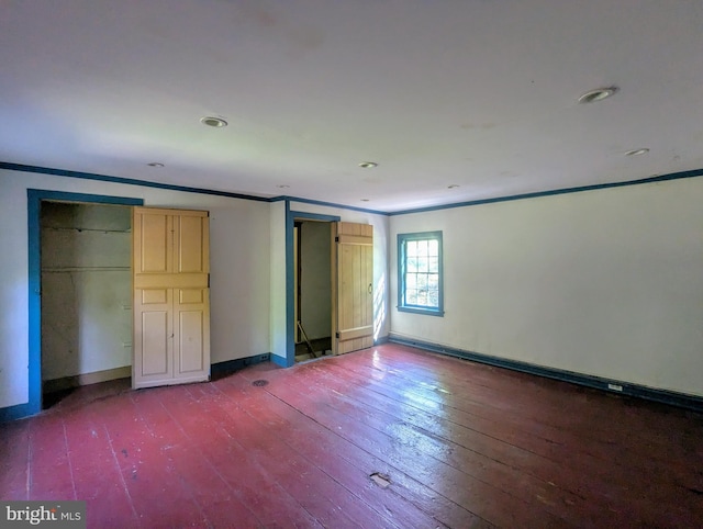 unfurnished bedroom with crown molding and hardwood / wood-style flooring