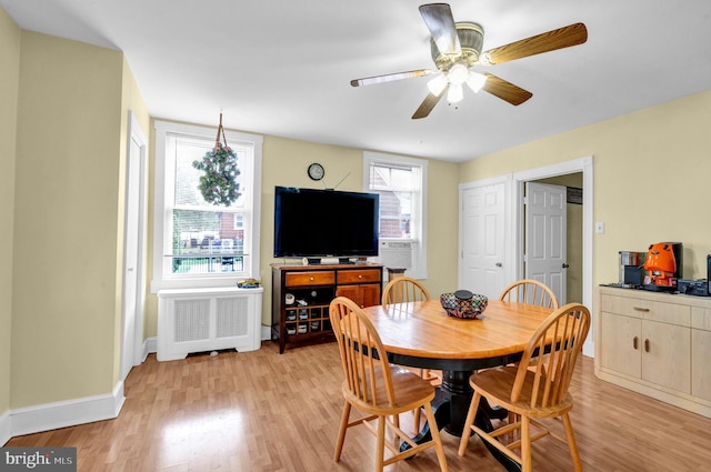 dining space with radiator, ceiling fan, and light hardwood / wood-style flooring