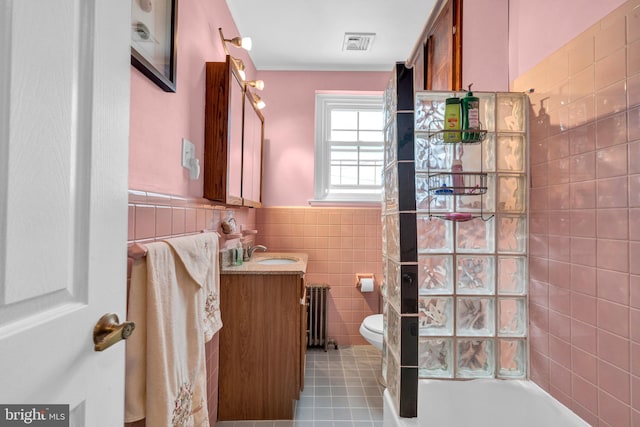 full bathroom featuring radiator, tile walls, tile patterned floors, vanity, and toilet