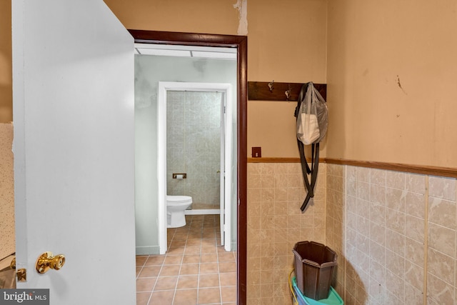 bathroom with tile walls, toilet, and tile patterned floors