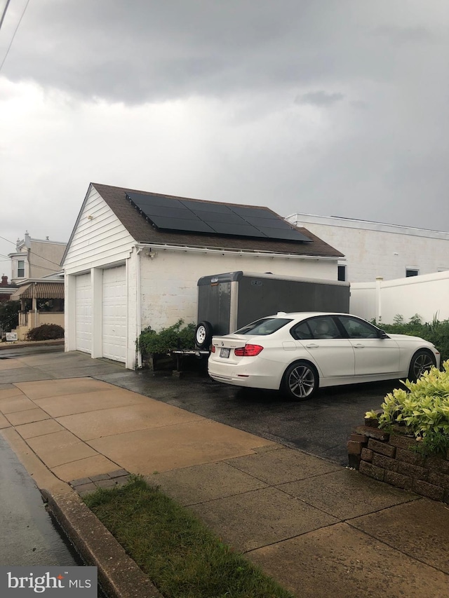 view of home's exterior featuring a garage and solar panels