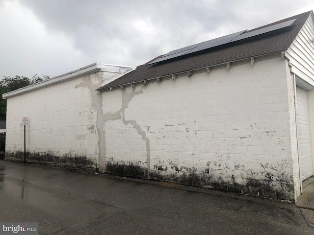 view of side of property featuring a garage and solar panels