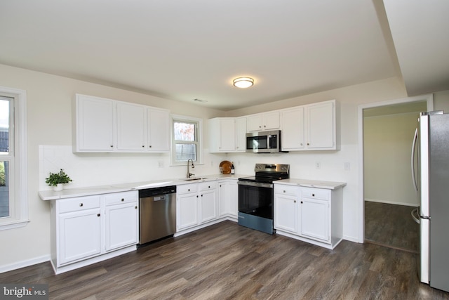 kitchen featuring dark wood-type flooring, white cabinetry, sink, and stainless steel appliances