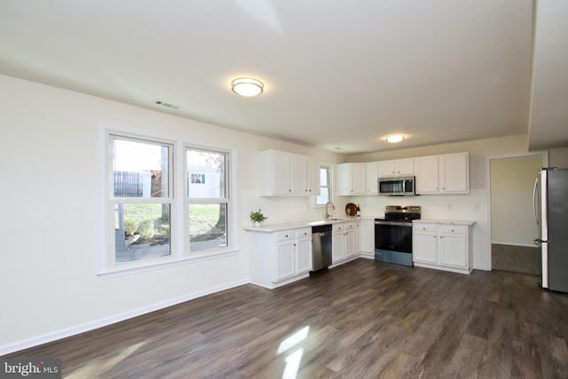 kitchen featuring white cabinetry, dark wood-type flooring, stainless steel appliances, and sink