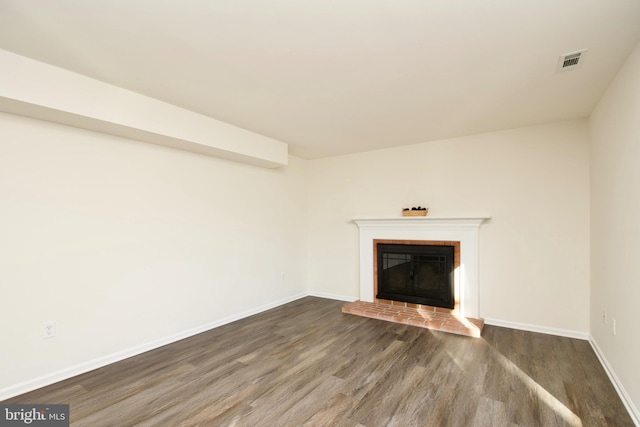 unfurnished living room with a fireplace and dark wood-type flooring