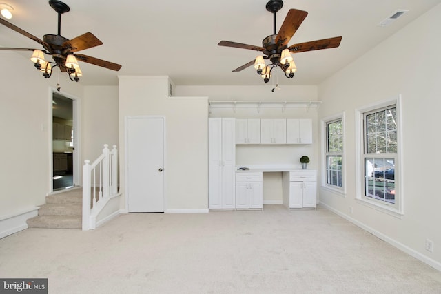 unfurnished living room with light colored carpet and ceiling fan