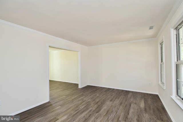 empty room featuring crown molding and dark wood-type flooring