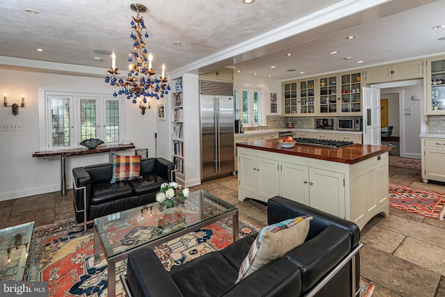 living room featuring ornamental molding, a notable chandelier, and a textured ceiling