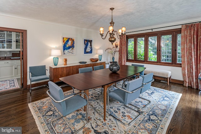 dining area featuring dark wood-type flooring, ornamental molding, an inviting chandelier, and a textured ceiling