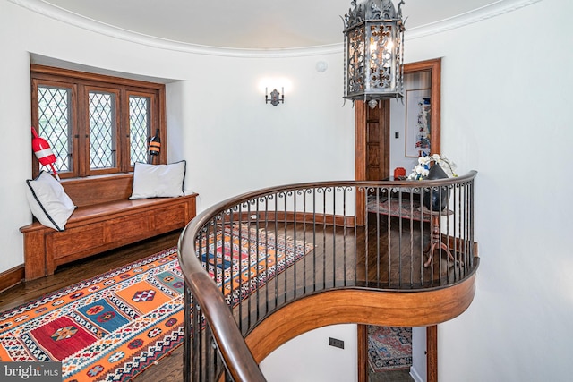 interior space with wood-type flooring, an inviting chandelier, and ornamental molding