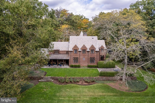 view of front of property featuring a front lawn and a patio area