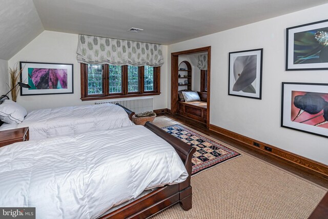 bedroom featuring wood-type flooring and lofted ceiling