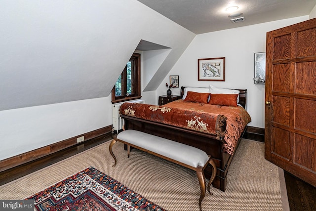 bedroom featuring wood-type flooring and lofted ceiling