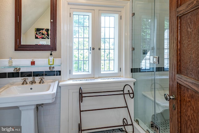 bathroom featuring walk in shower and tile walls