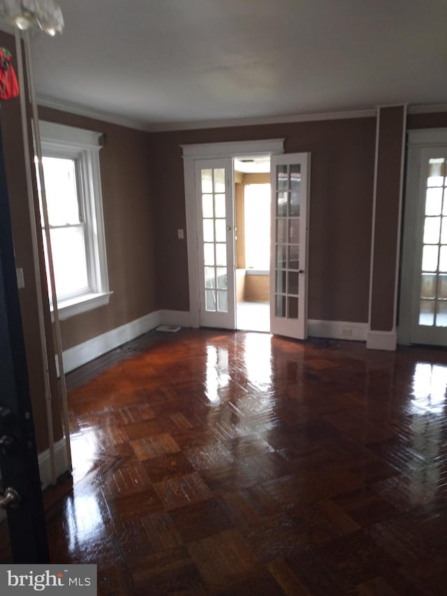 unfurnished room with french doors, dark parquet floors, and ornamental molding