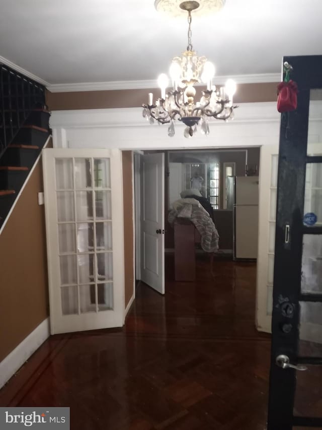 hall with ornamental molding, a chandelier, and parquet floors