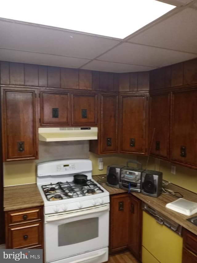 kitchen featuring a paneled ceiling and white range with gas cooktop