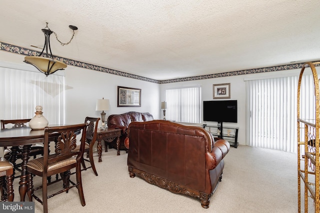 living room featuring light carpet, a wealth of natural light, and a textured ceiling