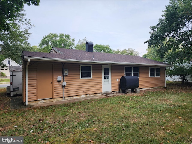 back of property featuring a lawn