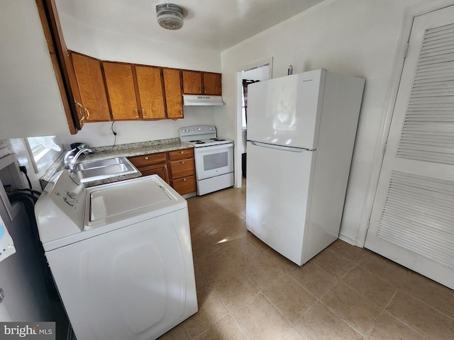 kitchen with washing machine and dryer, sink, and white appliances