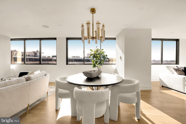 dining area featuring light hardwood / wood-style floors, an inviting chandelier, and floor to ceiling windows