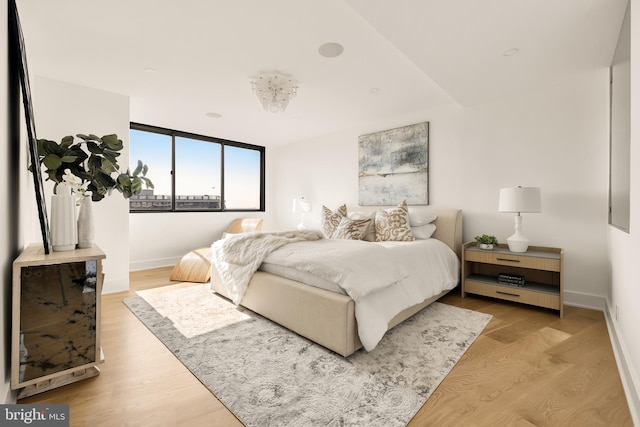 bedroom with expansive windows and light hardwood / wood-style floors