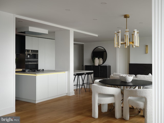 dining space featuring an inviting chandelier and light wood-type flooring