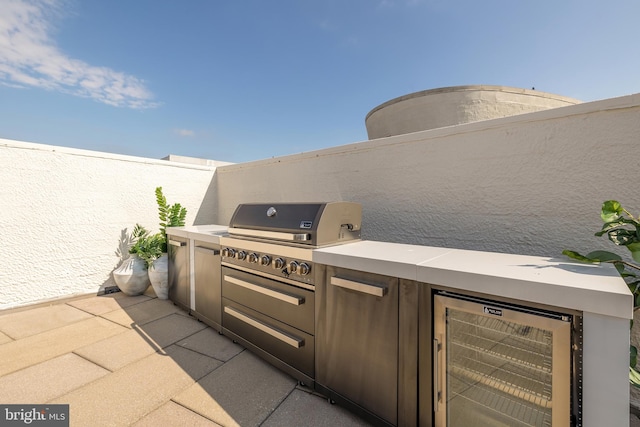 view of patio with exterior kitchen, beverage cooler, and grilling area