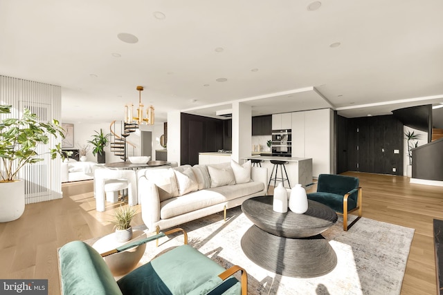 living room featuring light wood-type flooring and a chandelier