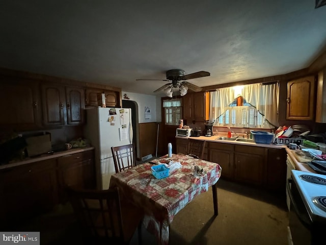 kitchen featuring white appliances, sink, ceiling fan, and light colored carpet