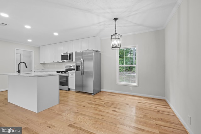 kitchen with hanging light fixtures, stainless steel appliances, sink, light wood-type flooring, and white cabinets