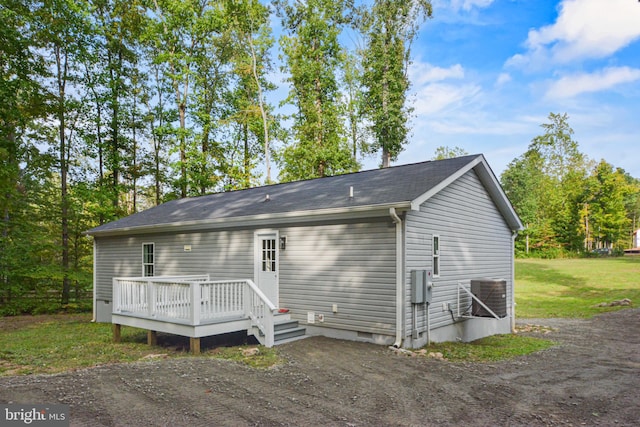 rear view of property featuring a deck and a yard