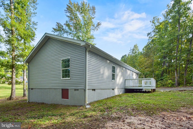 view of property exterior featuring a wooden deck and a lawn