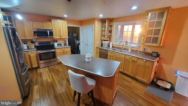 kitchen with a kitchen island, dark hardwood / wood-style floors, appliances with stainless steel finishes, and sink