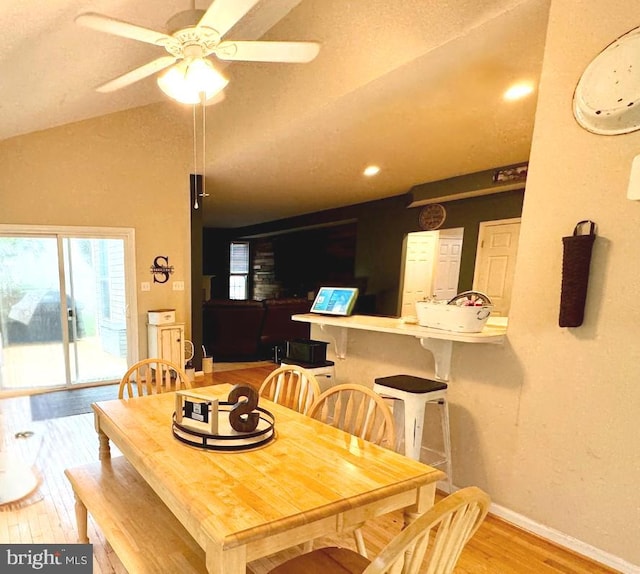 dining area with a ceiling fan, baseboards, vaulted ceiling, and wood finished floors