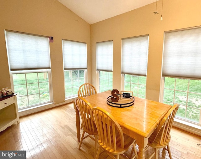 dining area with vaulted ceiling, light wood-type flooring, and a wealth of natural light