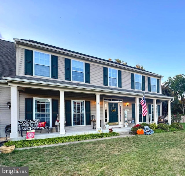 view of front of home featuring covered porch and a front lawn