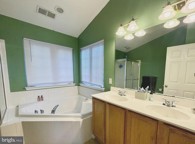 bathroom featuring independent shower and bath, vanity, and vaulted ceiling