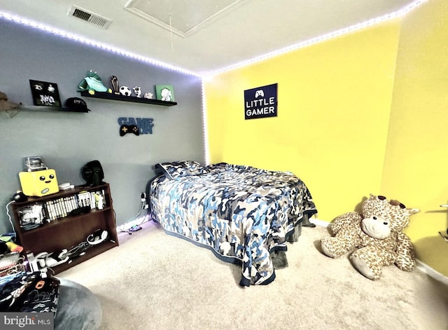 bedroom featuring attic access, visible vents, and carpet floors