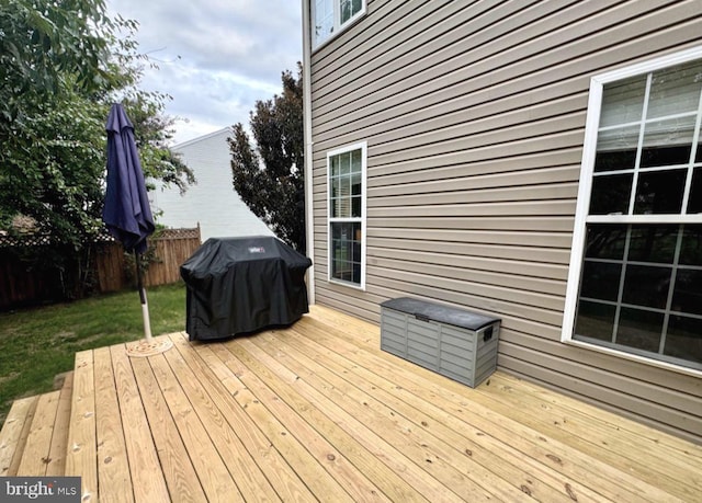 wooden deck featuring a grill and fence