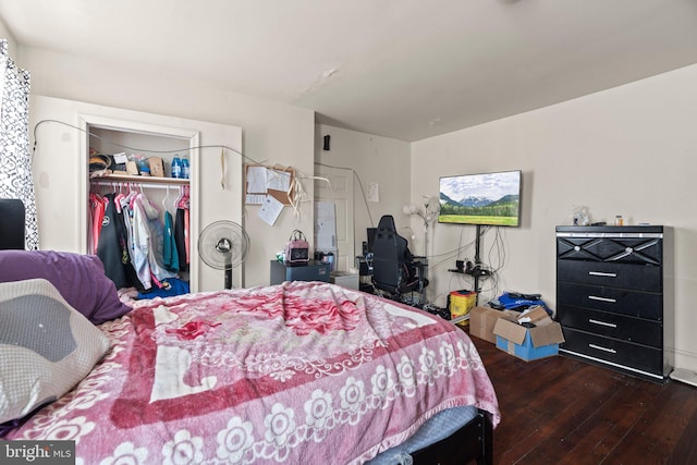 bedroom with dark hardwood / wood-style floors and a closet